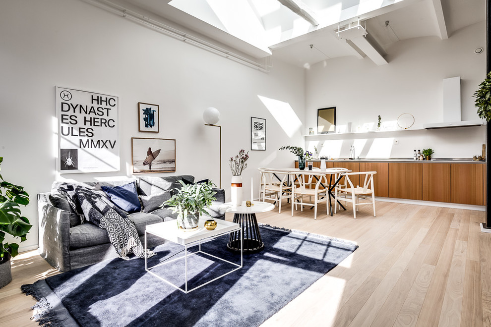 Design ideas for a mid-sized contemporary open concept living room in Stockholm with white walls and light hardwood floors.