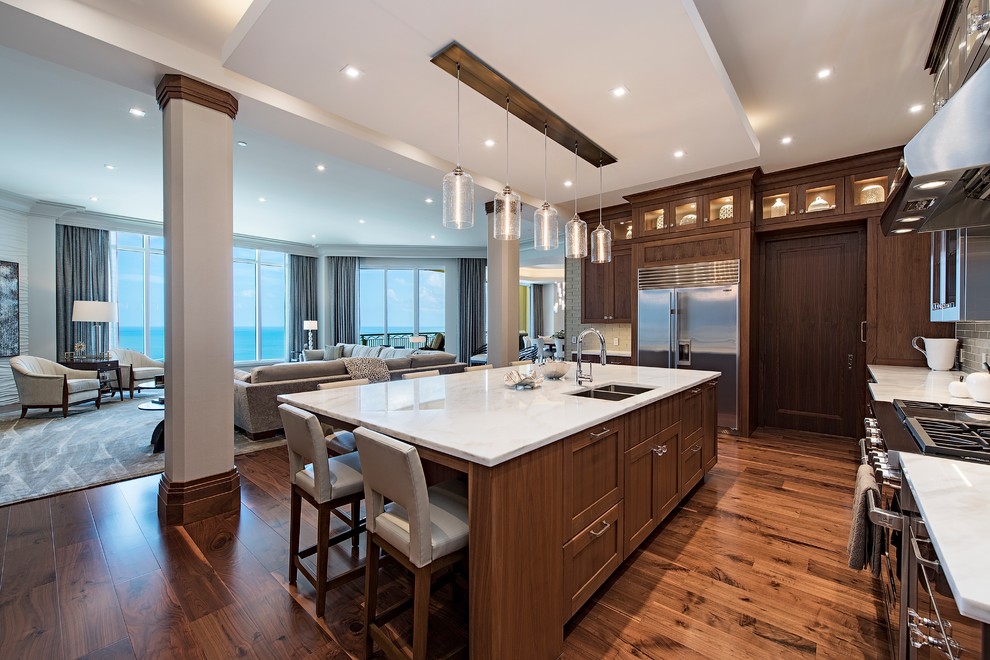 Inspiration for a transitional l-shaped kitchen in Other with an integrated sink, shaker cabinets, dark wood cabinets, dark hardwood floors, with island and brown floor.