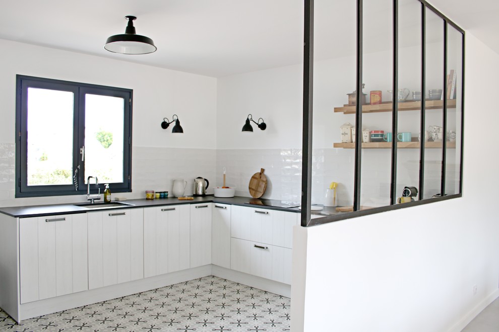 Inspiration for a mid-sized industrial u-shaped open plan kitchen with an integrated sink, louvered cabinets, white cabinets, quartz benchtops, white splashback, stainless steel appliances, cement tiles, no island, grey floor, ceramic splashback and black benchtop.