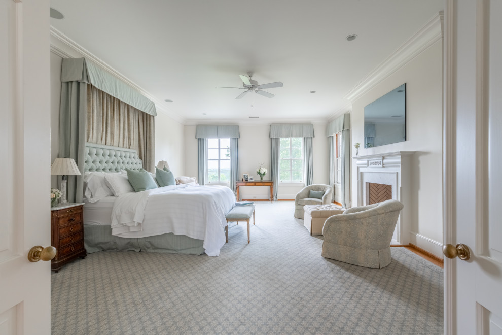 На фото: большая хозяйская спальня в классическом стиле с белыми стенами, ковровым покрытием, стандартным камином и фасадом камина из дерева