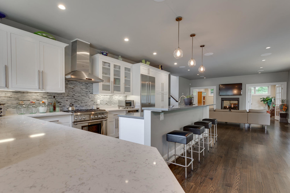 Mid-sized transitional l-shaped dark wood floor open concept kitchen photo in Orange County with shaker cabinets, white cabinets, marble countertops, multicolored backsplash, matchstick tile backsplash, stainless steel appliances and an island
