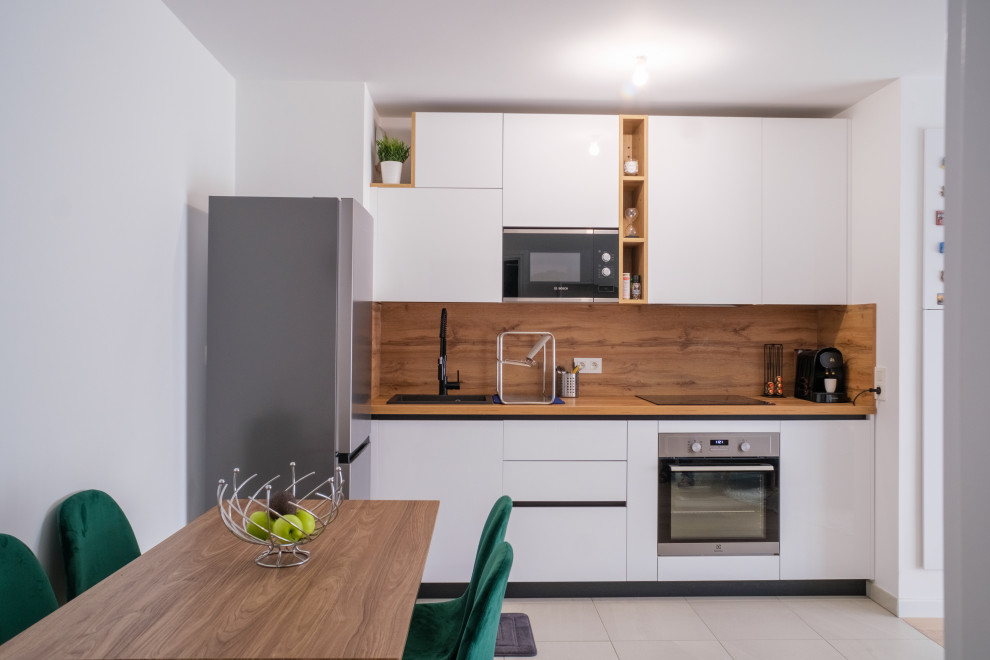 Inspiration pour une cuisine ouverte linéaire et blanche et bois minimaliste de taille moyenne avec un plan de travail en bois.