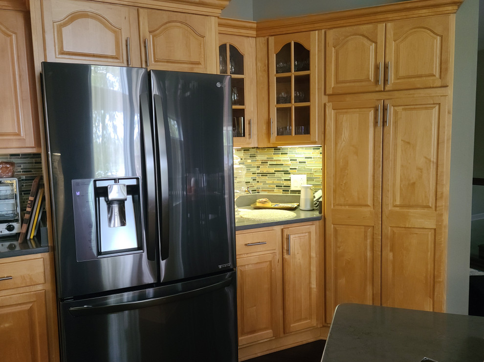 Inspiration for a mid-sized transitional u-shaped dark wood floor and brown floor open concept kitchen remodel with an undermount sink, shaker cabinets, yellow cabinets, quartzite countertops, brown backsplash, glass tile backsplash, stainless steel appliances, a peninsula and gray countertops