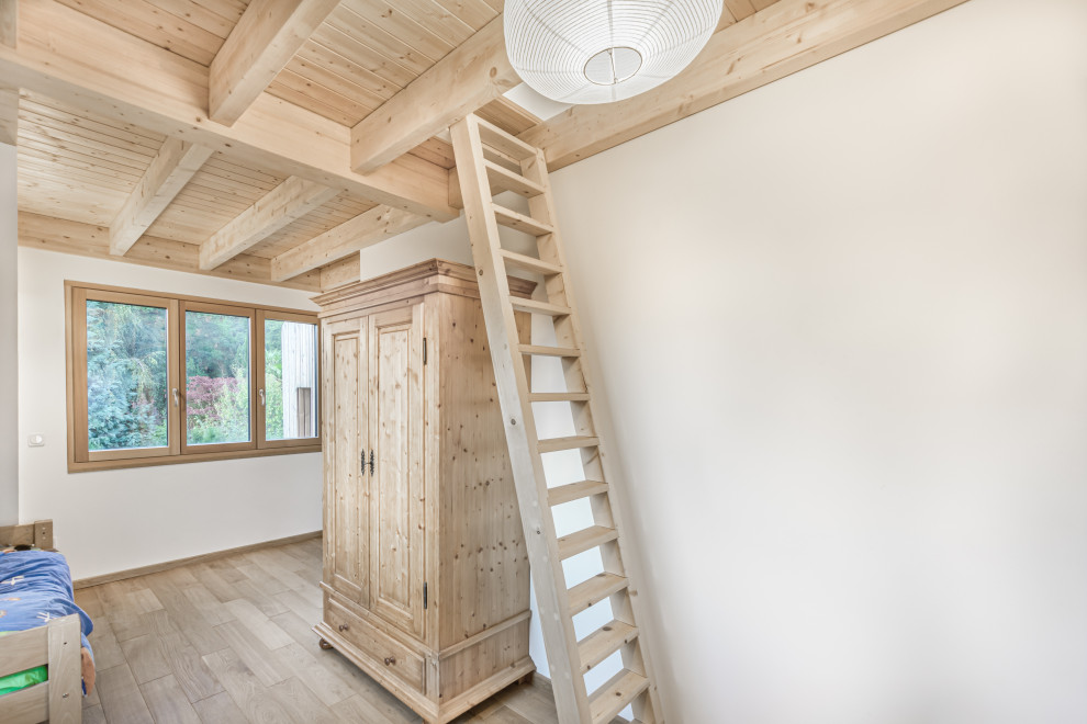 Immagine di una cameretta da letto scandinava di medie dimensioni con pareti bianche, parquet chiaro e soffitto in legno