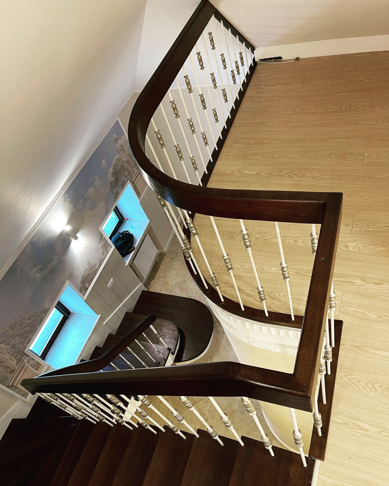 Exemple d'un escalier courbe victorien de taille moyenne avec des marches en bois, des contremarches en bois, un garde-corps en métal et du papier peint.