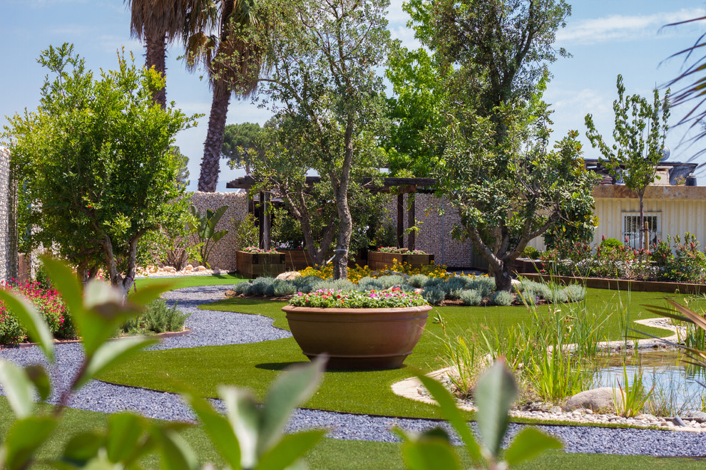 Photo of a large tropical front yard full sun driveway in Barcelona with a garden path.