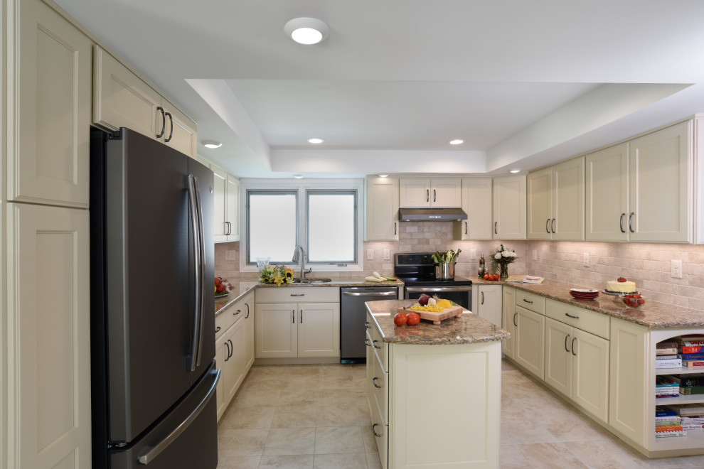 Mid-sized transitional u-shaped porcelain tile, beige floor and tray ceiling enclosed kitchen photo with an undermount sink, flat-panel cabinets, beige cabinets, quartz countertops, beige backsplash, travertine backsplash, black appliances, an island and beige countertops