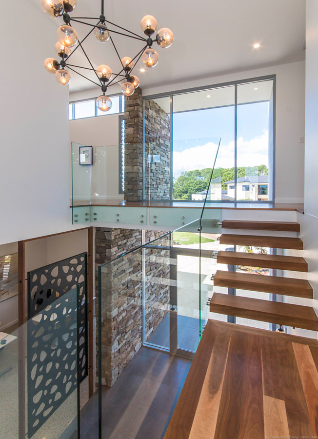 This is an example of a mid-sized contemporary wood floating staircase in Gold Coast - Tweed with open risers.