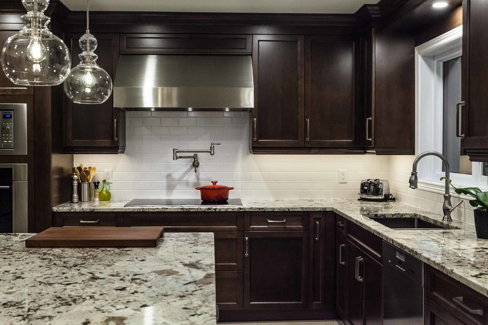 Large traditional l-shaped separate kitchen in Toronto with an undermount sink, recessed-panel cabinets, brown cabinets, granite benchtops, white splashback, porcelain splashback, stainless steel appliances, porcelain floors, with island, beige floor and beige benchtop.