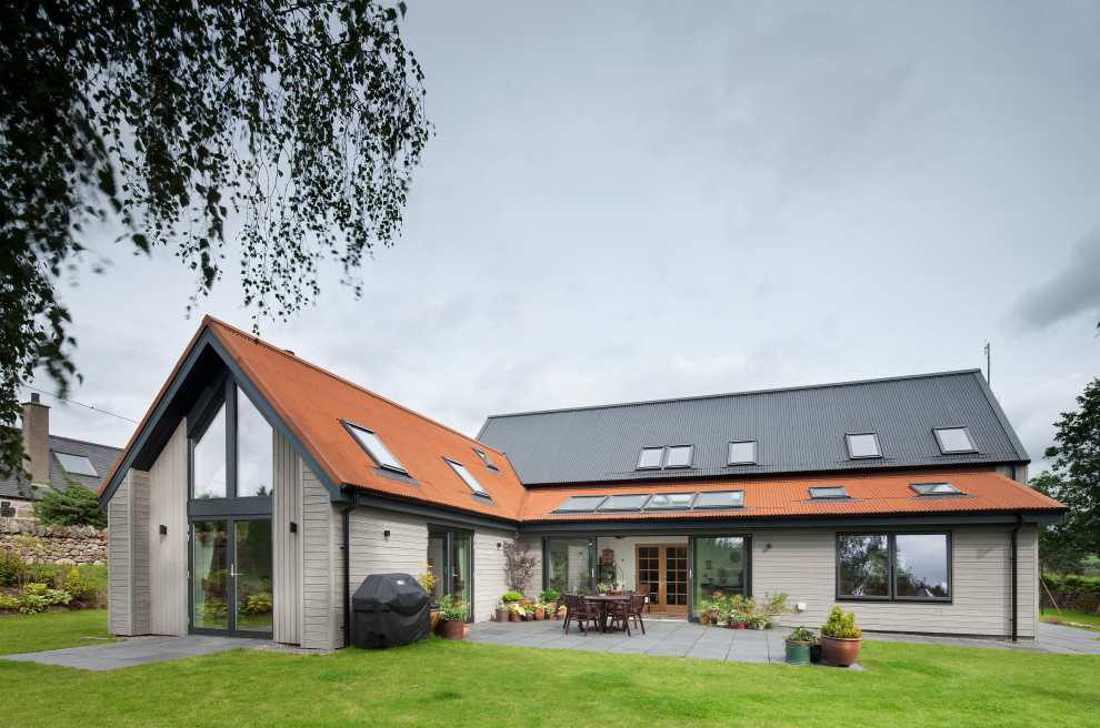 Inspiration for a medium sized contemporary two floor detached house in Other with wood cladding, a pitched roof, a metal roof, a grey roof and board and batten cladding.