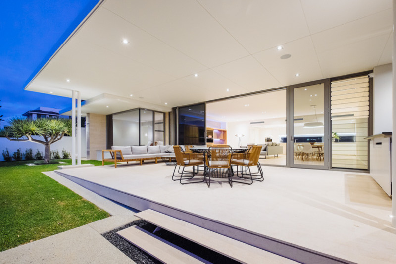 Photo of a mid-sized contemporary front yard patio in Perth with natural stone pavers and a roof extension.