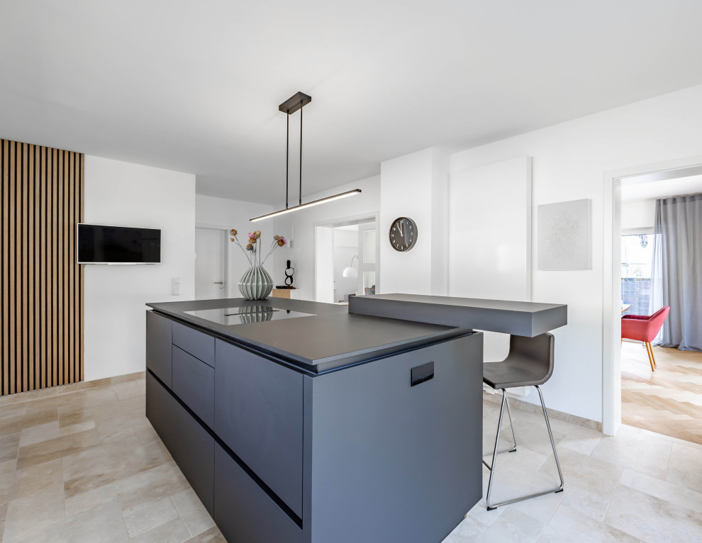 Immagine di una grande cucina design con ante lisce, ante nere, pavimento in travertino, pavimento beige e top nero