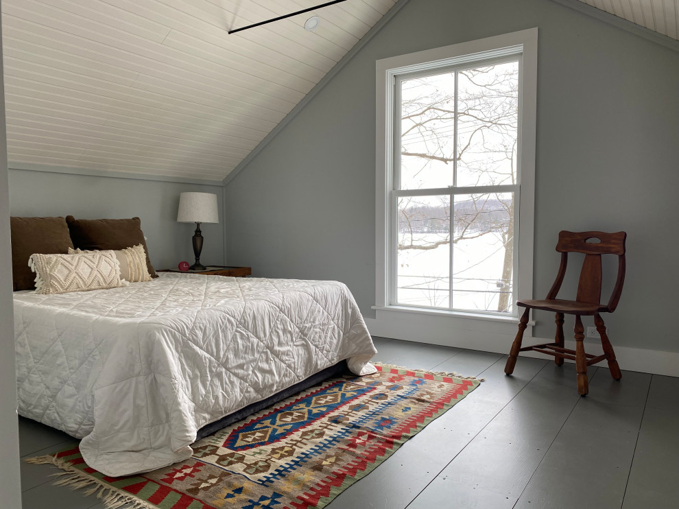 На фото: гостевая спальня среднего размера, (комната для гостей) в стиле кантри с серыми стенами, деревянным полом, серым полом и сводчатым потолком