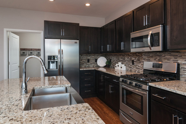 Inspiration for a transitional l-shaped kitchen remodel with an island, shaker cabinets and dark wood cabinets