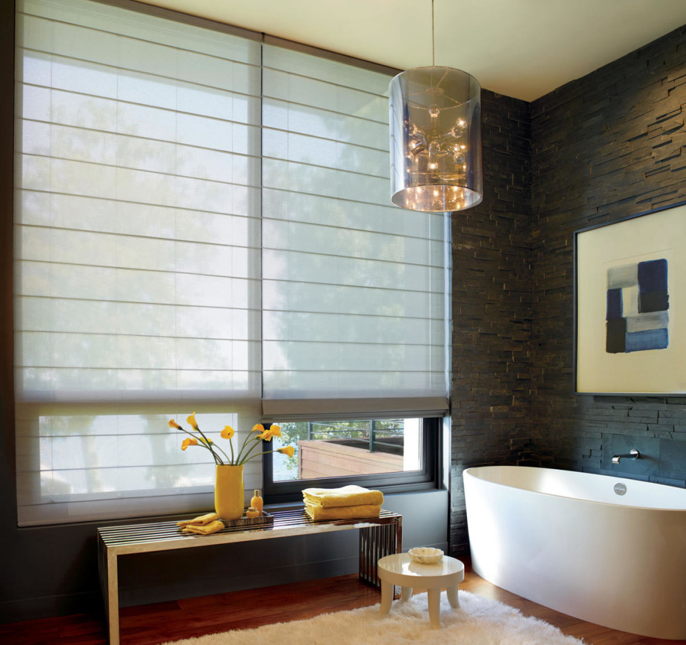 Стильный дизайн: главная ванная комната в стиле модернизм с отдельно стоящей ванной, черной плиткой, каменной плиткой, черными стенами, паркетным полом среднего тона и коричневым полом - последний тренд