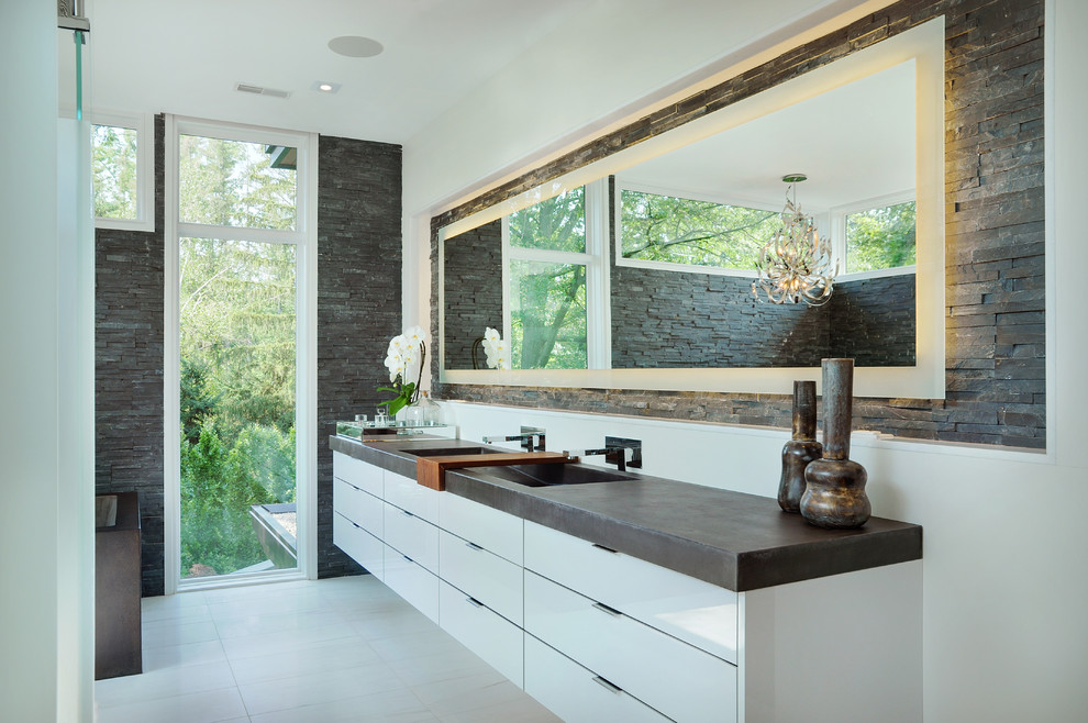 Photo of a large contemporary master bathroom in Toronto with flat-panel cabinets, white cabinets, an integrated sink, gray tile, stone tile and white walls.