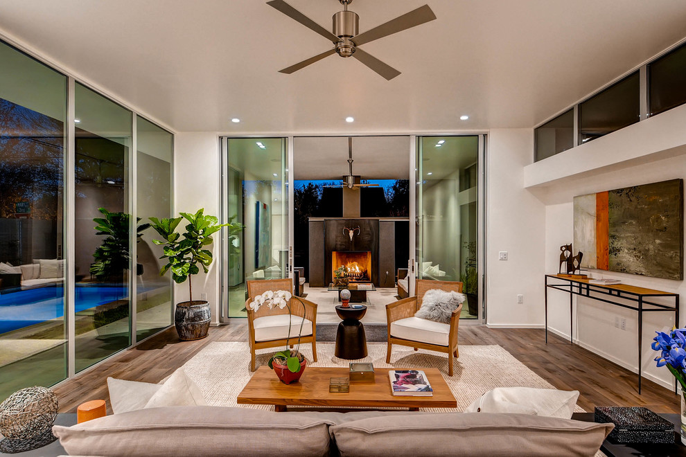 Large contemporary formal open concept living room in Austin with white walls, medium hardwood floors and no tv.