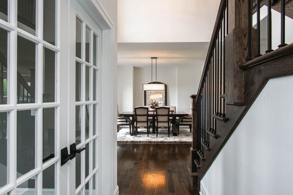 Transitional dark wood floor and black floor hallway photo in Chicago with white walls