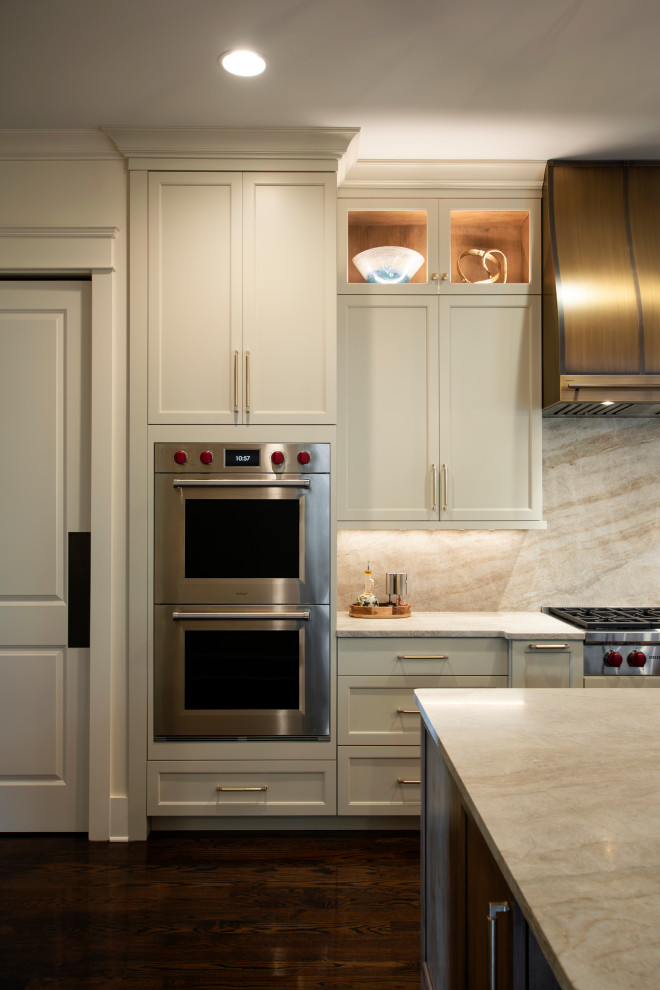 Inspiration for a large transitional l-shaped dark wood floor and brown floor open concept kitchen remodel in Nashville with an undermount sink, beaded inset cabinets, white cabinets, quartzite countertops, beige backsplash, stone slab backsplash, stainless steel appliances, an island and beige countertops