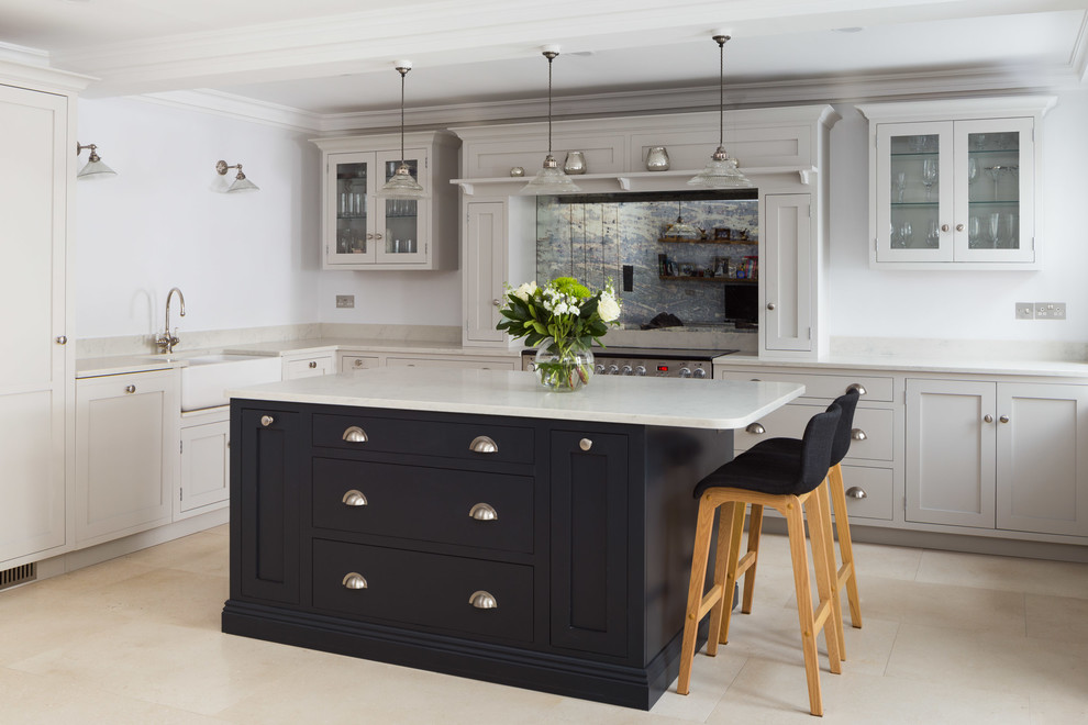 Photo of a large traditional l-shaped eat-in kitchen in Other with a drop-in sink, shaker cabinets, granite benchtops, metallic splashback, glass sheet splashback, stainless steel appliances, limestone floors, with island, beige floor and white benchtop.