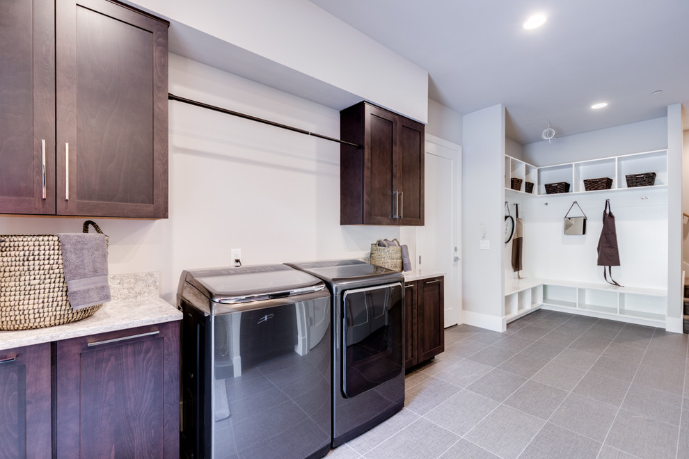 Photo of a large contemporary galley utility room in Seattle with an undermount sink, shaker cabinets, dark wood cabinets, granite benchtops, white walls, porcelain floors, a side-by-side washer and dryer, grey floor and multi-coloured benchtop.