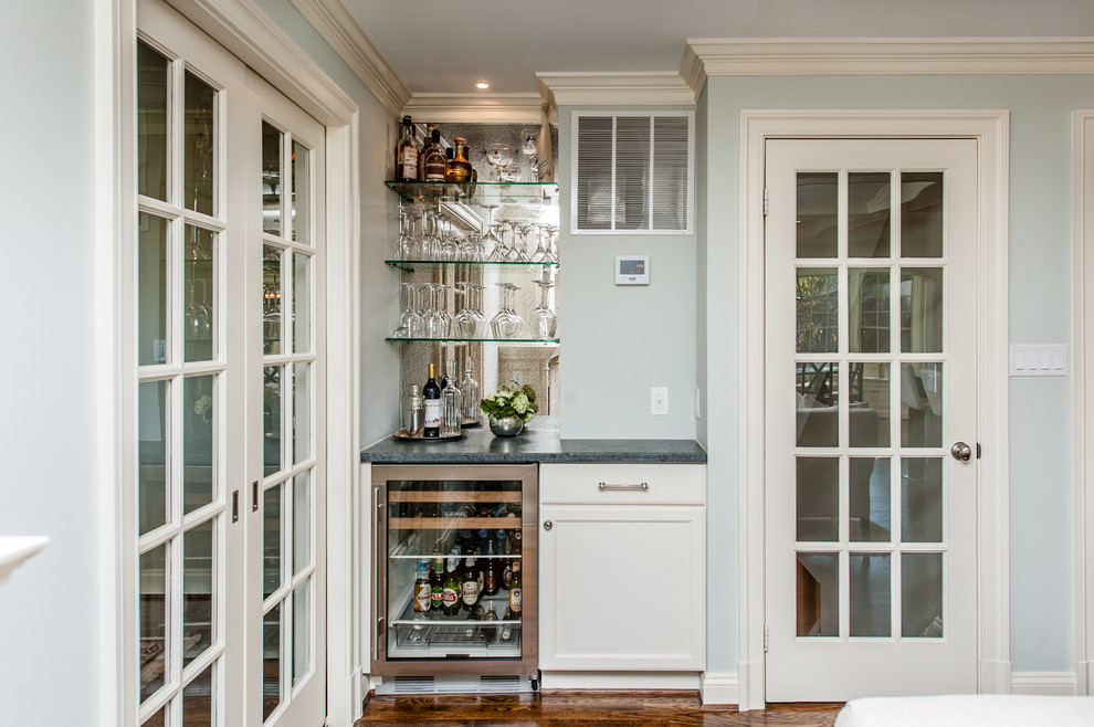 Inspiration for a small transitional home bar in DC Metro with recessed-panel cabinets, white cabinets, granite benchtops and medium hardwood floors.