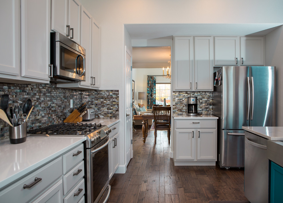 Open concept kitchen - mid-sized transitional l-shaped dark wood floor and brown floor open concept kitchen idea in Denver with a farmhouse sink, shaker cabinets, white cabinets, marble countertops, metallic backsplash, matchstick tile backsplash, paneled appliances, an island and gray countertops