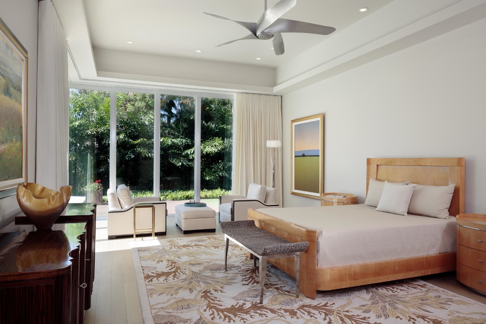 This is an example of a mid-sized modern master bedroom in Miami with white walls and light hardwood floors.