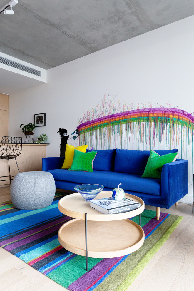 Inspiration for a small contemporary open concept living room in Melbourne with white walls, light hardwood floors, a wall-mounted tv and beige floor.