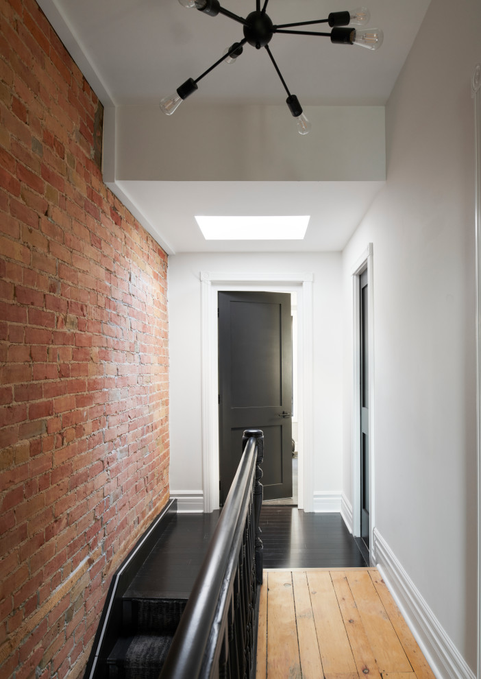 トロントにある高級な小さなコンテンポラリースタイルのおしゃれな直階段 (カーペット張りの蹴込み板、木材の手すり、レンガ壁) の写真