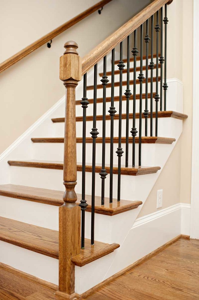 Classic wood staircase in Charlotte with painted wood risers.