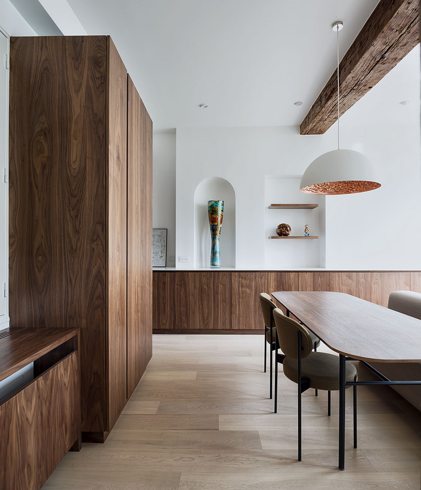 Modern dining room in Paris with white walls, light hardwood floors and beige floor.