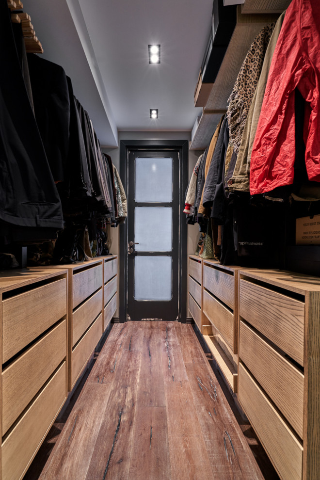 Idéer för stora walk-in-closets för män, med släta luckor, skåp i ljust trä, mellanmörkt trägolv och brunt golv