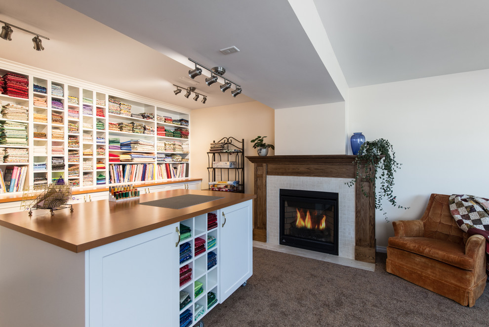 Photo of a large traditional craft room in Vancouver with beige walls, carpet, a standard fireplace, a freestanding desk and a tile fireplace surround.