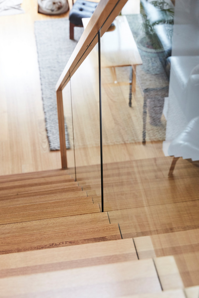 This is an example of a mid-sized contemporary wood straight staircase in Melbourne with wood risers.
