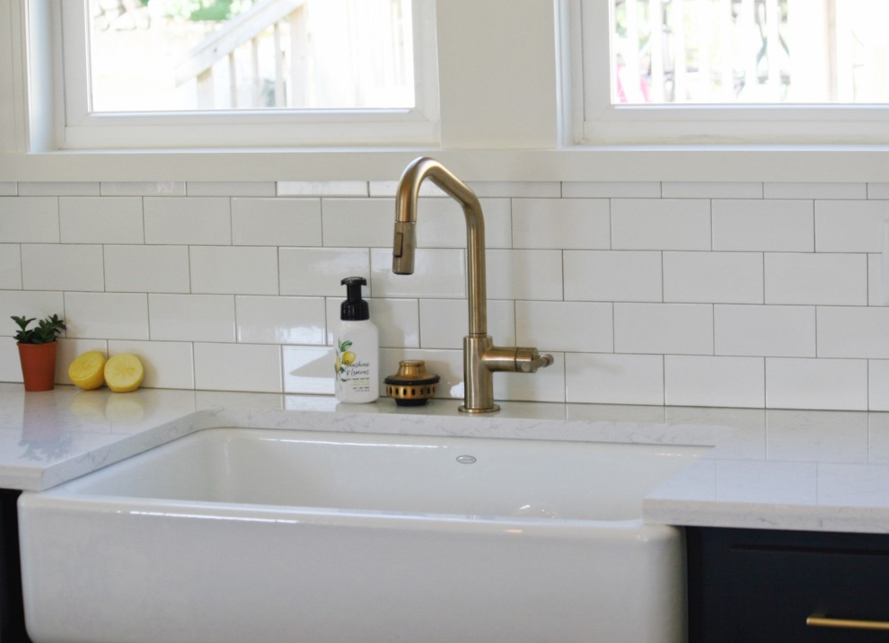Example of a transitional gray floor kitchen design with a farmhouse sink, quartz countertops and stainless steel appliances