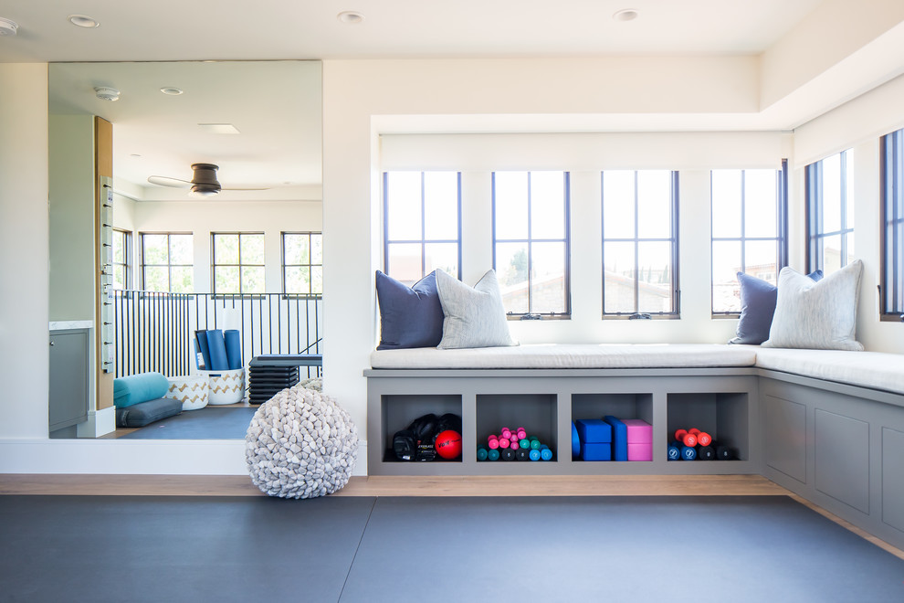 Large mediterranean home yoga studio in Orange County with white walls, medium hardwood floors and brown floor.