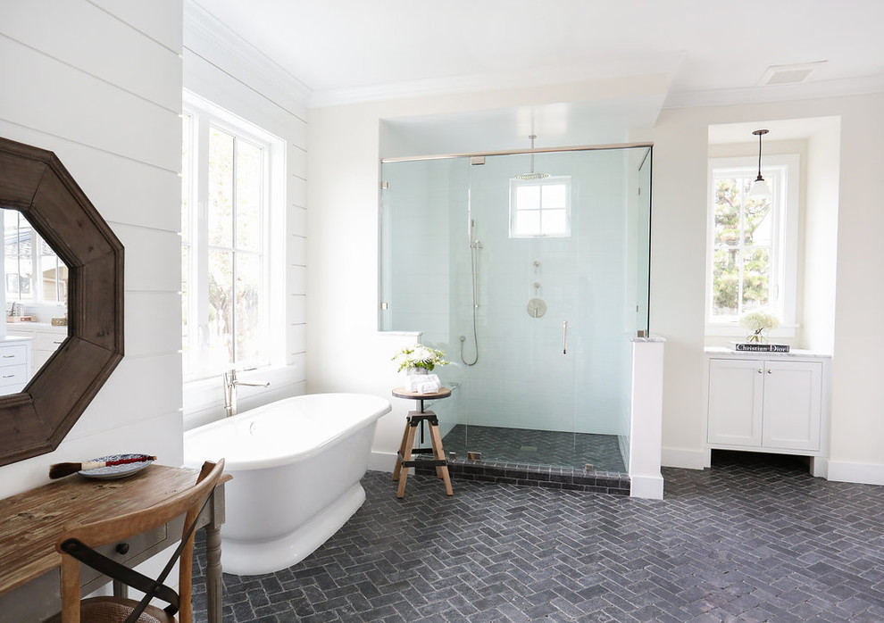 Inspiration for a country master bathroom in Orange County with blue tile, white walls, limestone floors and a corner shower.