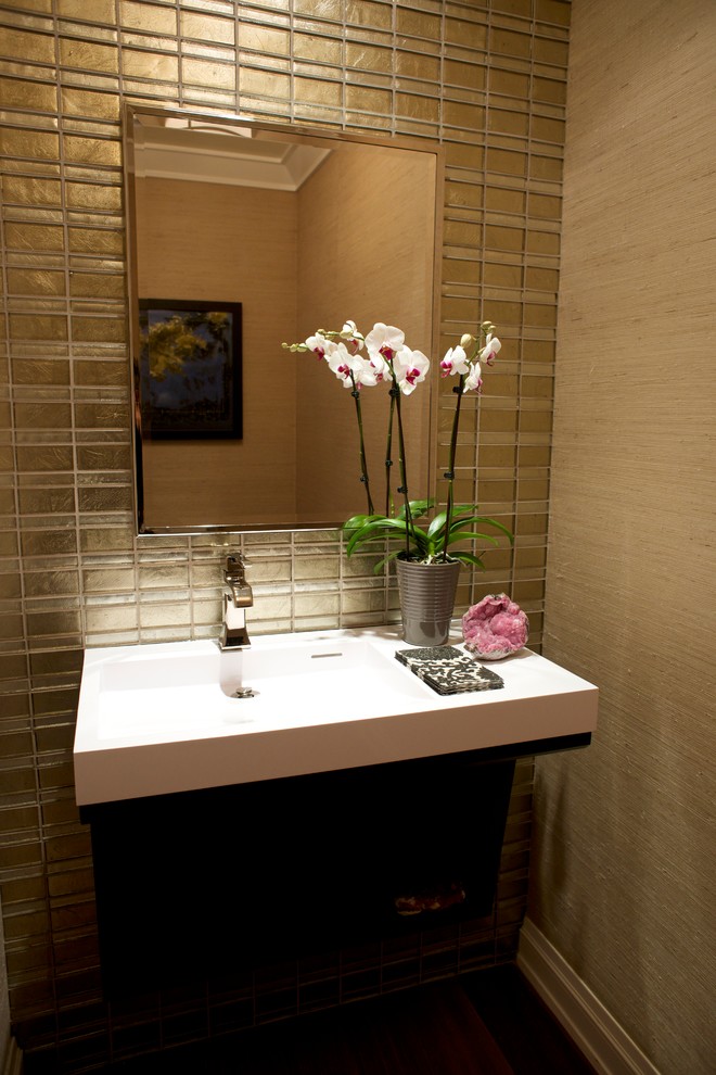 Small contemporary powder room in Los Angeles with glass tile, beige walls, dark hardwood floors and an integrated sink.