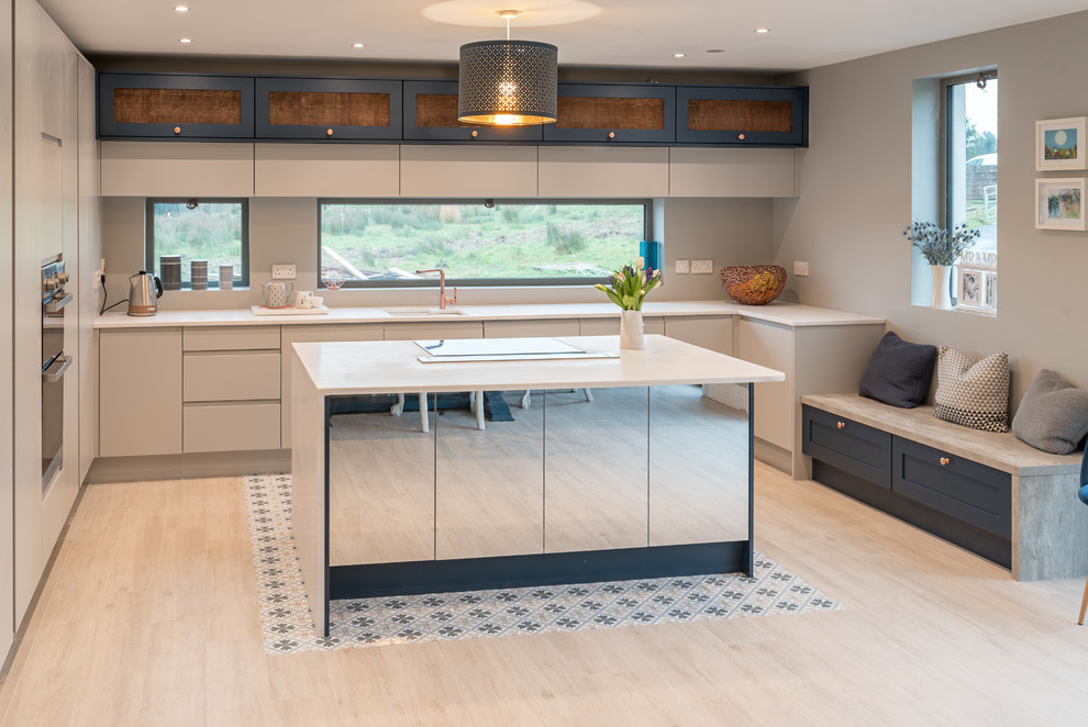 Inspiration for a large contemporary l-shaped eat-in kitchen in Dublin with grey cabinets, with island, an undermount sink, flat-panel cabinets, beige splashback, panelled appliances, light hardwood floors, black floor and beige benchtop.