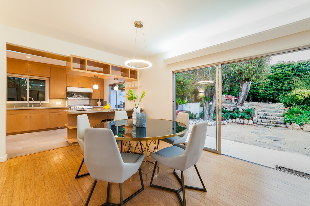Mid-sized midcentury open plan dining in Los Angeles with light hardwood floors.