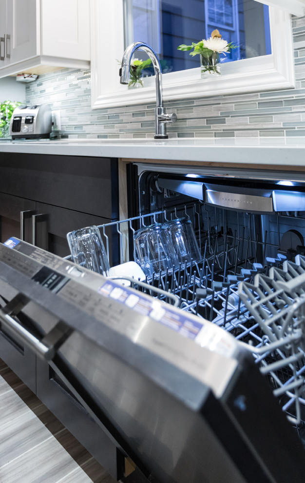 Example of a mid-sized trendy porcelain tile and gray floor kitchen design with an undermount sink, shaker cabinets, gray cabinets, solid surface countertops, multicolored backsplash, matchstick tile backsplash and stainless steel appliances