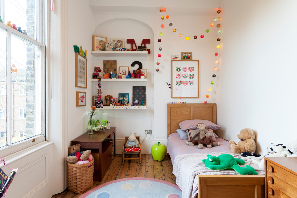 Inspiration for an eclectic gender-neutral kids' room in London with white walls and medium hardwood floors.