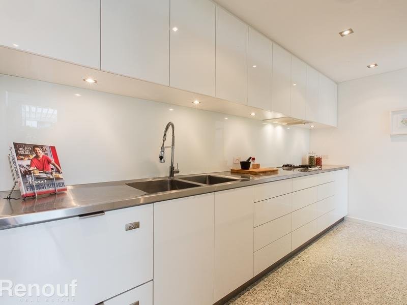 Design ideas for a large modern galley kitchen pantry in Perth with an integrated sink, flat-panel cabinets, white cabinets, stainless steel benchtops, white splashback, glass sheet splashback, coloured appliances, concrete floors and with island.