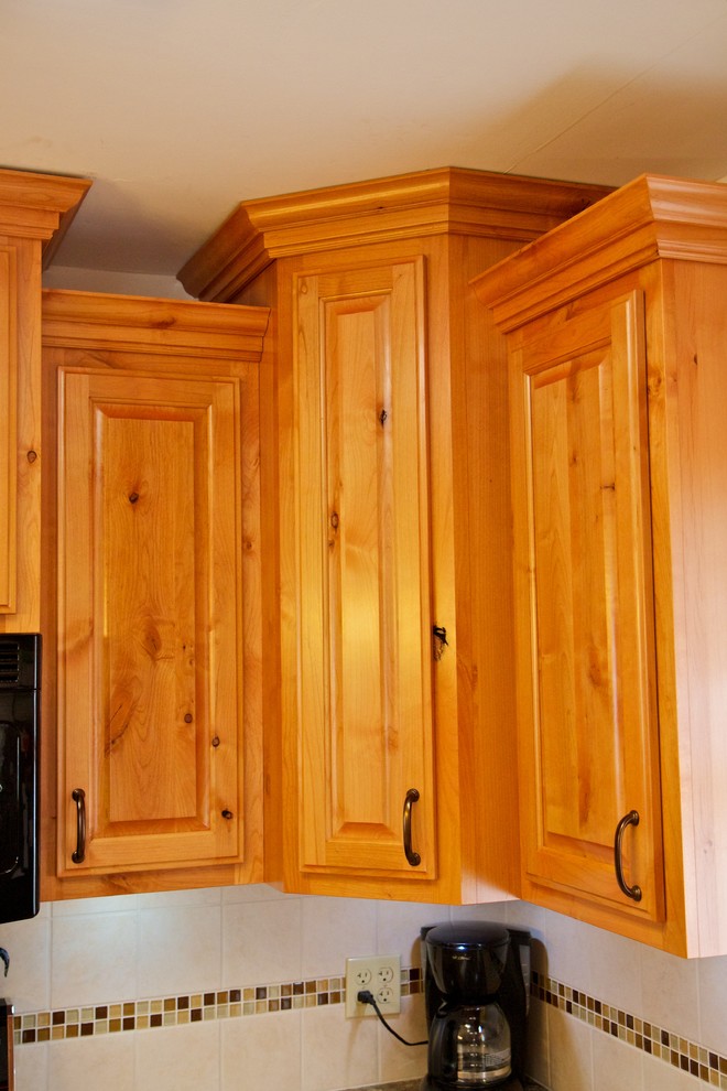 Inspiration for a small u-shaped open concept kitchen remodel with a drop-in sink, raised-panel cabinets, light wood cabinets, laminate countertops, white backsplash, stainless steel appliances and a peninsula