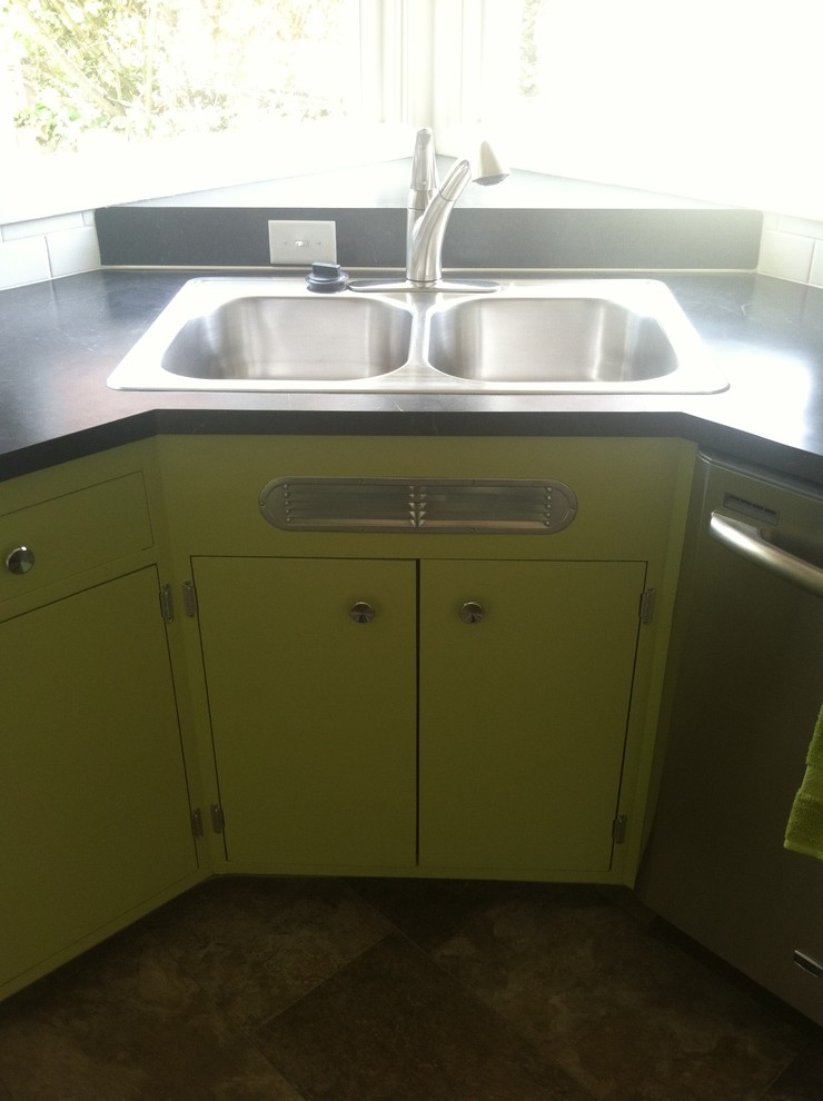 This is an example of a mid-sized midcentury l-shaped separate kitchen in Portland with a drop-in sink, flat-panel cabinets, green cabinets, laminate benchtops, white splashback, ceramic splashback, stainless steel appliances, vinyl floors and a peninsula.