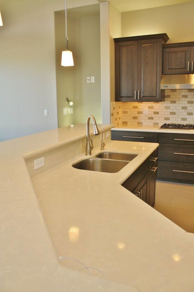 Large transitional u-shaped porcelain tile eat-in kitchen photo in Phoenix with an undermount sink, raised-panel cabinets, dark wood cabinets, quartz countertops, beige backsplash, stone tile backsplash, stainless steel appliances and an island