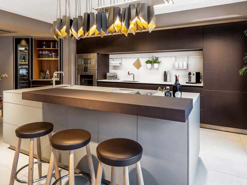 Inspiration for a large modern single-wall eat-in kitchen in Other with an integrated sink, flat-panel cabinets, dark wood cabinets, quartz benchtops, white splashback, engineered quartz splashback, stainless steel appliances, porcelain floors, with island and white benchtop.