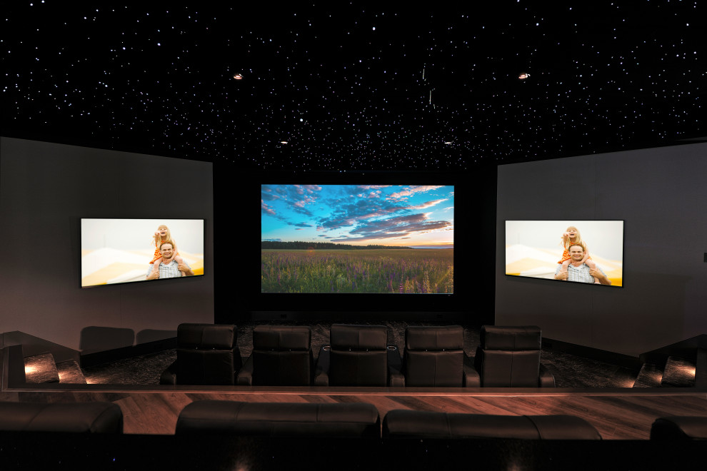 Photo of a large modern open concept home theatre in Indianapolis with beige walls, carpet, a wall-mounted tv and grey floor.