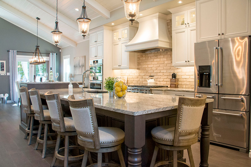 Inspiration for a large transitional l-shaped eat-in kitchen remodel with a double-bowl sink, shaker cabinets, white cabinets, beige backsplash, stainless steel appliances and an island